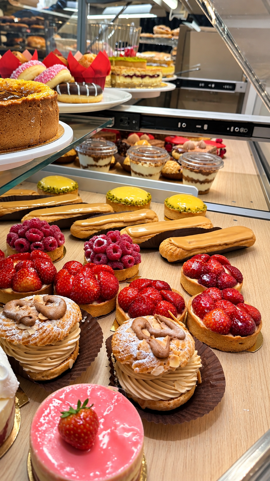 Vitrine de pâtisseries, éclairs et tartelettes aux fruits
