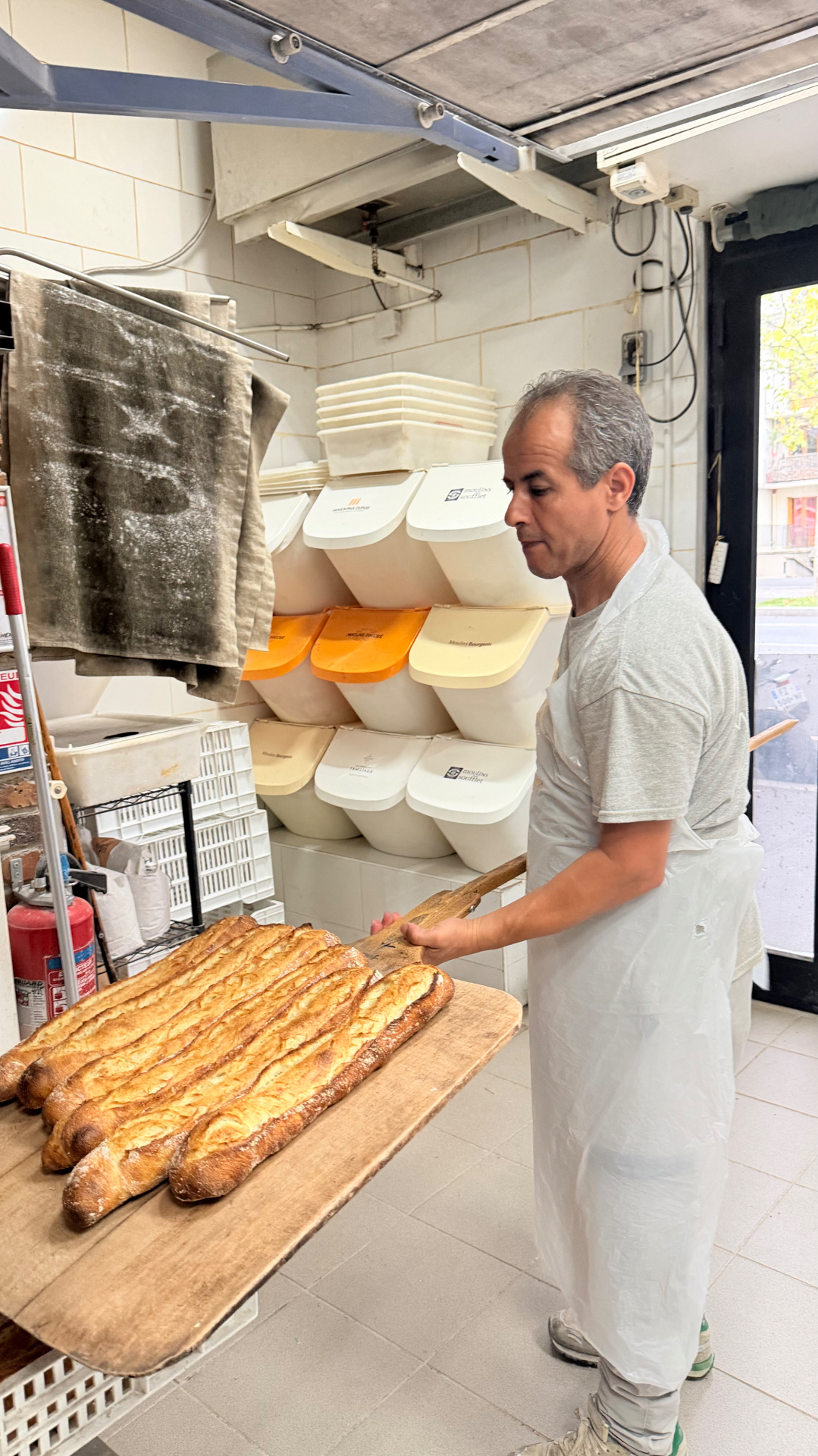 Le boulanger avec des baguettes sur sa pelle à pain